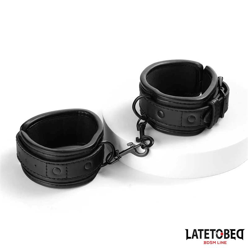 LateToBed "BDSM Line" esposas para tobillo acolchadas con cadena negra